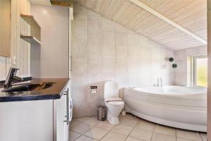a bathroom with a tub and a toilet and a sink at LF550-Vestervig-Ingersvej-20 in Vestervig +13 photos