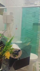 a bathroom with a glass sink and a phone at a Casa Paradisiaca lll Luxo Com Sinuca e Lavanderia com Roupa de Cama e Toalhas in Caldas Novas
