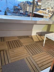 a wooden floor on a balcony with a view of a city at Studio la mongie de 33m2 à 150 m des pistes in La Mongie