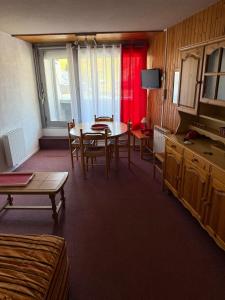 a room with a table and chairs and a television at Studio la mongie de 33m2 à 150 m des pistes in La Mongie +7 photos