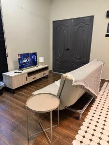 een woonkamer met een stoel en een bureau met een computer bij Ariyanie Roomstay 2 in Kuala Terengganu