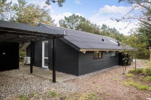 a black house with a black roof at LF581-Hurup-Thy-Haettemagevej-1 in Sindrup