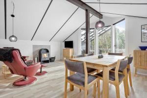 a dining room with a table and chairs and a fireplace at LF581-Hurup-Thy-Haettemagevej-1 in Sindrup