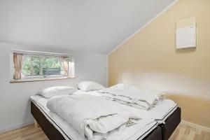 a bedroom with a bed with white sheets and a window at LF581-Hurup-Thy-Haettemagevej-1 in Sindrup