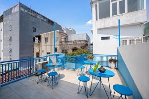 Un patio con mesas y taburetes azules en un balcón. en La Holly Home, en Hue