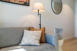 a living room with a couch with a lamp and a mirror at Velvet Dusk Suite @ Lv 29 on the new Star Casino in Brisbane +29 photos