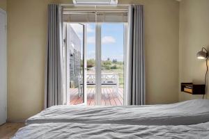 a bedroom with a bed and a sliding glass door at LF13025-Oster-Assels-Kanalstien-3 in Øster Assels