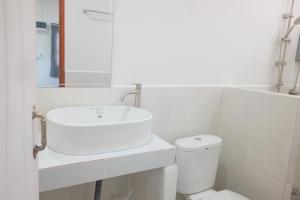 a white bathroom with a sink and a toilet at ศาลาลำดวนรีสอร์ต in Ban Sala Lamduan