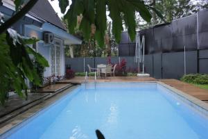 a swimming pool in a backyard with a table at Diyar Villas Puncak M3/47 in Puncak