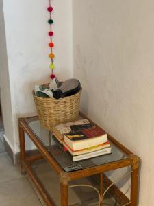 une table en verre avec un panier et des livres dessus dans l'établissement La Casita de Arte, à San Cristóbal de Las Casas