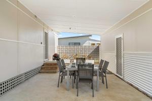 una sala da pranzo con tavolo e sedie di Whitewash Cottage by Experience Jervis Bay a Huskisson Altre 13 foto