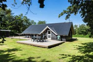 a small house with a deck and a table at LF12017-Spottrup-Albaekparken-144 in Spottrup