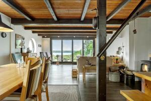 a dining room with wooden ceilings and a table and chairs at LF14160-Roslev-Pinen-52 in Roslev