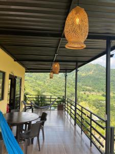 a room with tables and chairs and a balcony with a view at Romantic Glamping - Vista Impresionante Villeta Jacuzzi in Villeta