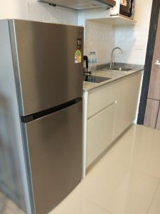 Ban Mai SalaeにあるNorth Gate Apartmentsのステンレス製の冷蔵庫とシンクを備えたキッチン