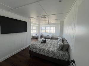 a bedroom with a bed and a flat screen tv at Hotel Theodore in Theodore