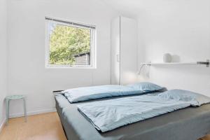 un letto in una stanza bianca con una finestra di LF338-Vestervig-Gunhildsvej-38 a Vestervig
