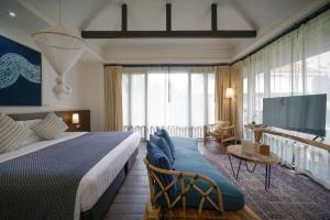 ein Hotelzimmer mit einem Bett und einem Fernseher in der Unterkunft Baan Saen Fang Chiang Mai in Chiang Mai