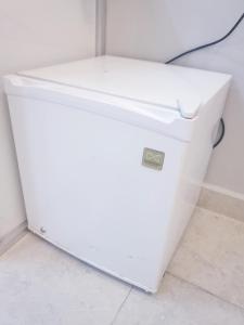 a white refrigerator sitting on the floor in a room at Al Buraq Economic Apartments in Salalah