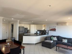 a living room with a couch and a kitchen at Tumby Bay Hotel Seafront Apartments in Tumby Bay