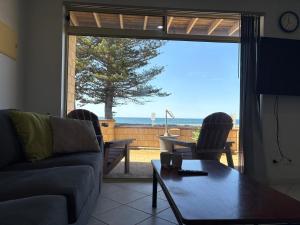 a living room with a couch and a table at Tumby Bay Hotel Seafront Apartments in Tumby Bay