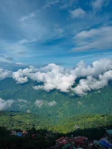 a view of a mountain with clouds in the sky at Raibas Homestay in Darjeeling +17 photos