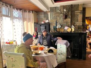 a group of people sitting at a table eating at Sherpa kheychu homestay in Darjeeling