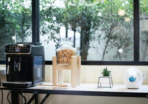 a counter with a microwave and a coffee maker on it at Baan Phor Phan Hotel in Khon Kaen