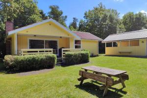 a yellow house with a picnic table in the yard at LF16244-Logstor-Mollysvej-44 in Løgstør