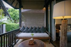 eine Veranda mit einer Bank und blauen Kissen darauf in der Unterkunft Baan Saen Fang Chiang Mai in Chiang Mai