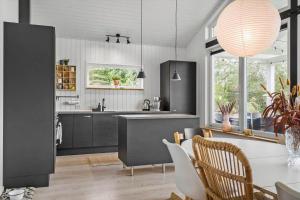a kitchen with a table and a dining room at LF10058-Thyholm-Fyrrevej-17 in Thyholm