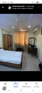 a picture of a bedroom with a bed and a desk at Dp Oberoi residency in Ernakulam