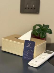 a remote control next to a box on a table at X Hotel Pattaya in Pattaya Central