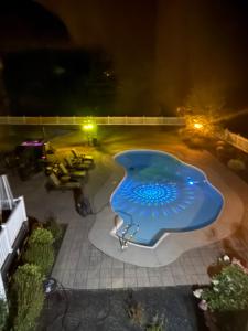 - une piscine avec un objet bleu la nuit dans l'établissement 9 Bedroom Saratoga Home, In-Ground Heated Pool, HotTub, Firepit, Gourmet Kitchen, Fireplace, Office, à Saratoga Springs