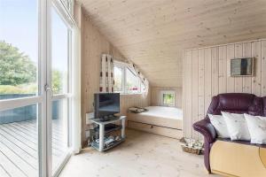 a room with a couch and a tv and a window at LF403-Hurup-Thy-Klydevej-6 in Sindrup