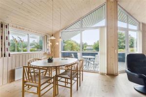 a dining room with a table and chairs and windows at LF403-Hurup-Thy-Klydevej-6 in Sindrup