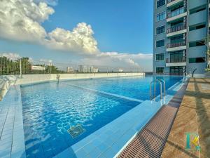 a large swimming pool next to a tall building at Optimus Medini By RR JBcity in Iskandar Puteri