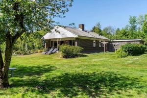 a house with a tree in a yard at LF10004-Thyholm-Agertoften-4 in Thyholm