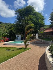 a palm tree next to a swimming pool at 5BR, Ocean View, Private Pool, Villas Roc-Azur in Sampalan
