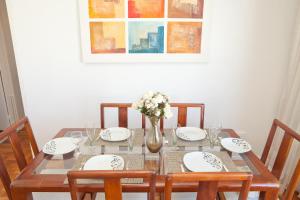 una mesa de comedor con un jarrón de flores en Apartamento completo na praia de COPACABANA, 3 SUITES , em andar alto com vista mar, ar ,wifi, tv canais a cabo, pauloangerami MVC18, en Río de Janeiro