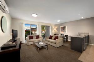 墨爾本的住宿－奎斯特摩尼山谷公寓酒店，客厅配有沙发和桌子
