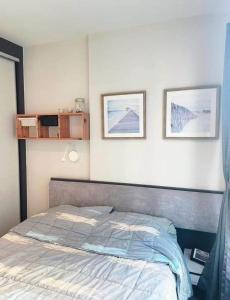 a bedroom with a bed with two pictures on the wall at The Base Pattaya Seaview Condo in Pattaya Central