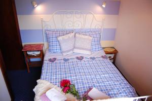 a bedroom with a bed with blue and white pillows at Pokoje Gościnne Pod Ciupagą in Bukowina Tatrzańska