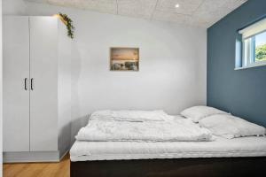 un letto in una camera con parete blu e bianca di LF12744-Ejsingholm-Kildebakken-44 a Ejsingholm
