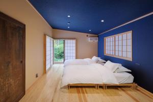 two beds in a room with a blue wall at 甚兵衛邸 in Hirado +68 photos
