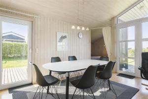 a dining room with a white table and black chairs at LF453-Vestervig-Hannesvej-23 in Vestervig +17 photos