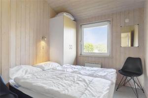 a bedroom with a bed and a chair and a window at LF453-Vestervig-Hannesvej-23 in Vestervig