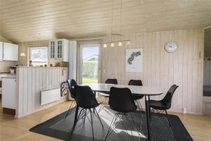 a dining room with a table and black chairs at LF453-Vestervig-Hannesvej-23 in Vestervig