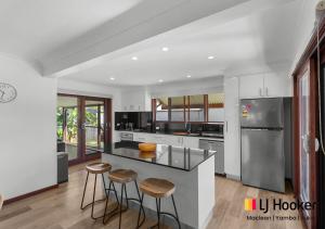 a kitchen with a counter and stools in it at River & Reef Retreat in Iluka