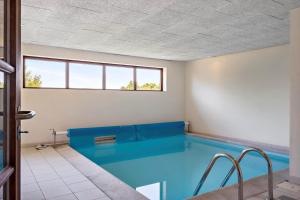 a swimming pool with a blue couch in a room at LF11597-Struer-Plantagevej-97 in Struer